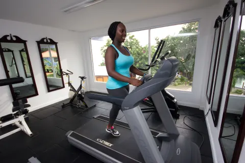 A guest uses a treadmill in the fitness room at True Blue Bay Resort.