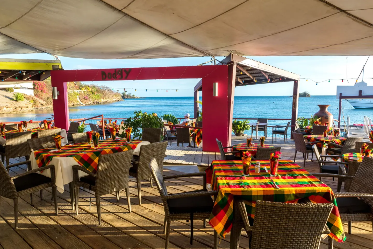 Waterfront dining deck with colorful tablecloths at True Blue Bay Resort.