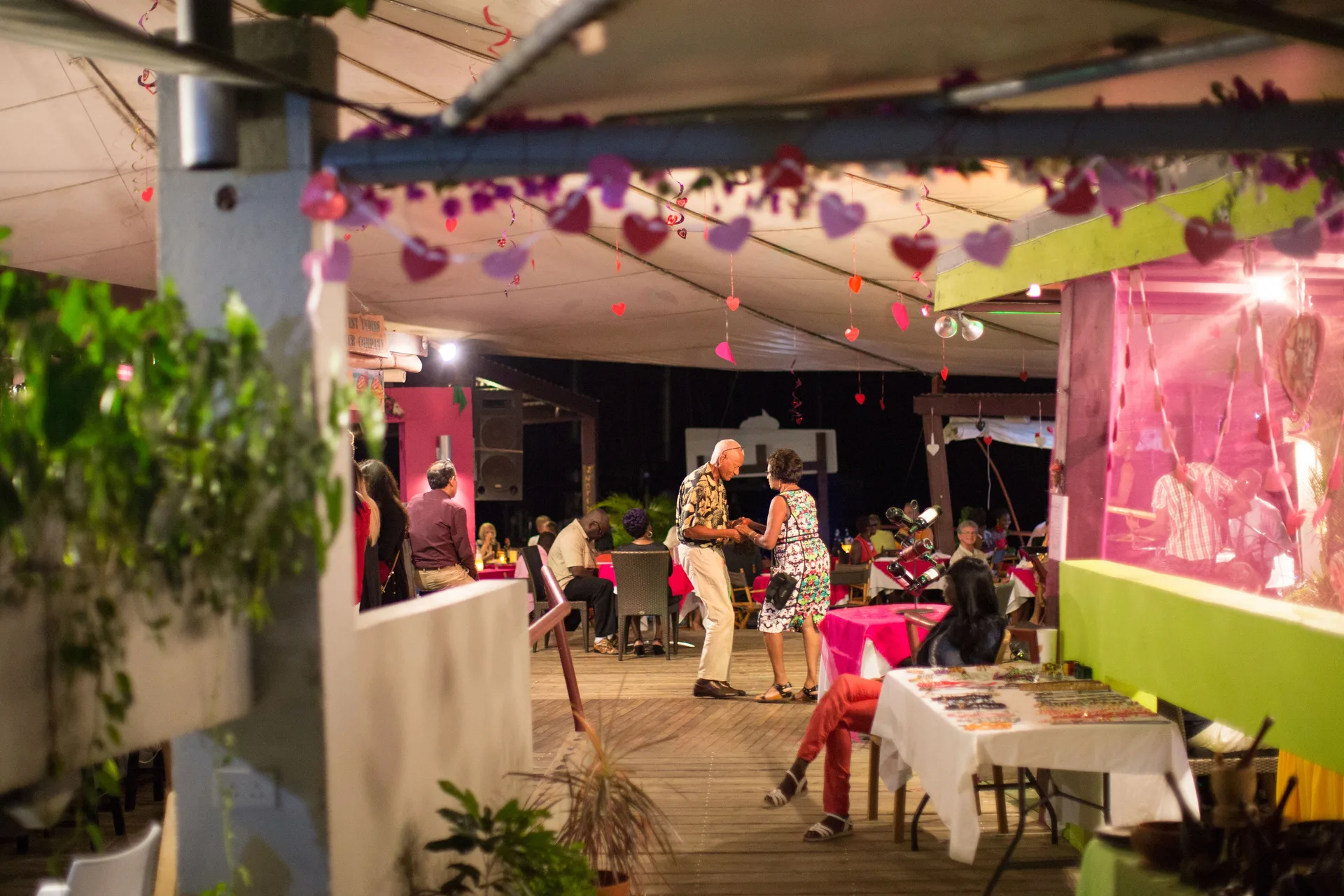Guests dance under hanging heart decorations at True Blue Bay Resort.