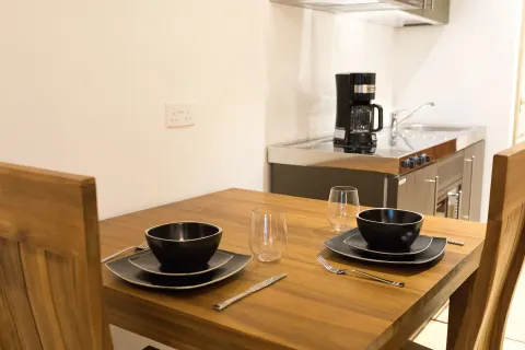 Cocoa Pod Room dining table and kitchenette at True Blue Bay Resort.