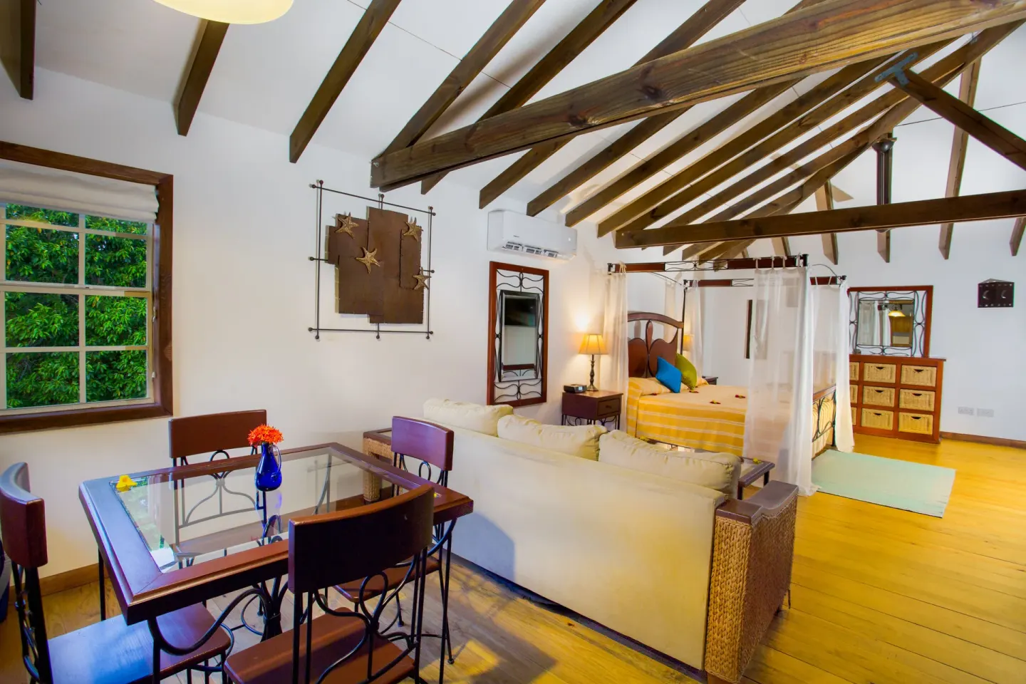 Tower Suite living and sleeping area with canopy bed at True Blue Bay Resort.