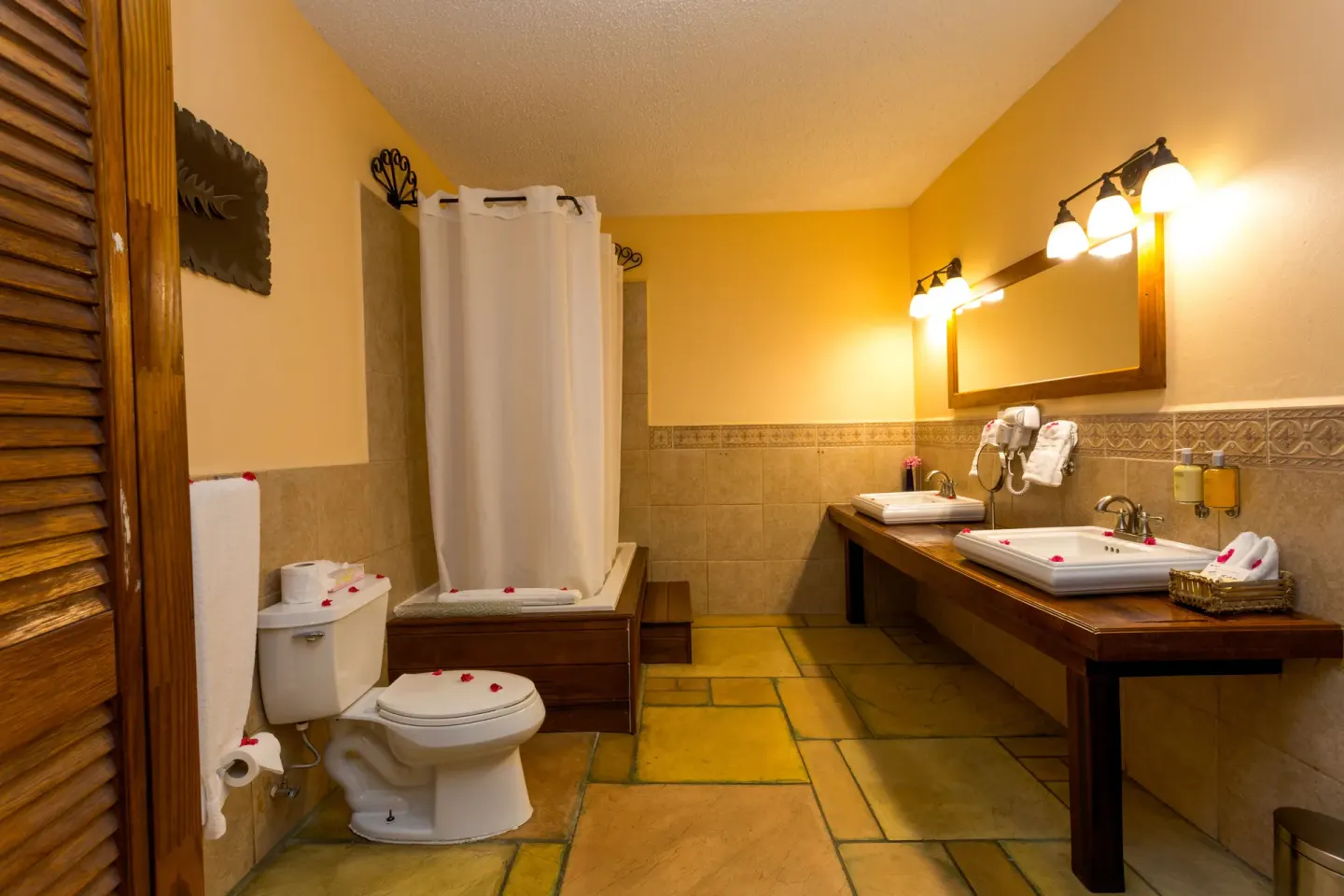 True Blue Bay Resort bathroom at True Blue Bay Resort with double sinks, shower curtain, and toilet.