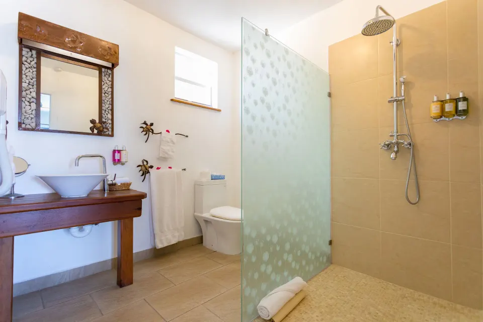 Waterfront Suite bathroom with glass shower at True Blue Bay Resort.