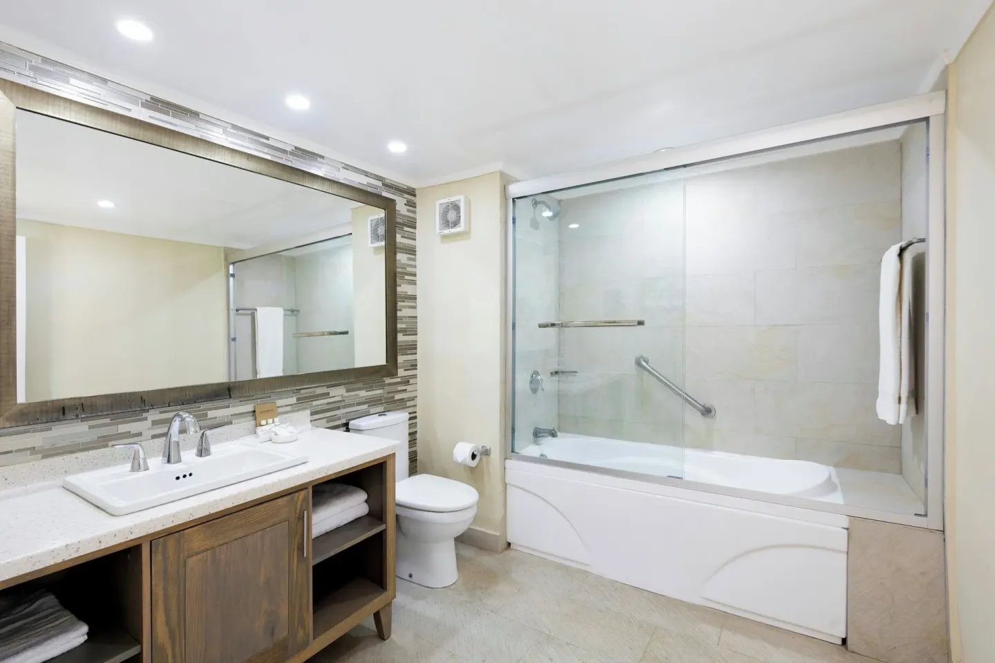 Bathroom with vanity, toilet and glass-enclosed tub shower at Turtle Beach.