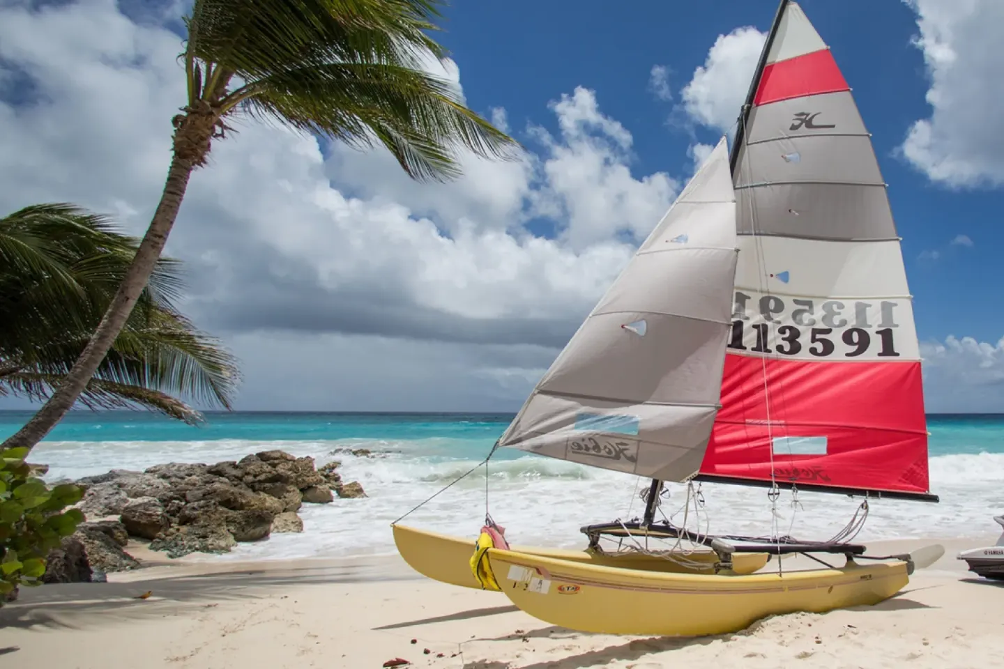 Beach catamaran on the sand beside turquoise water at Turtle Beach.