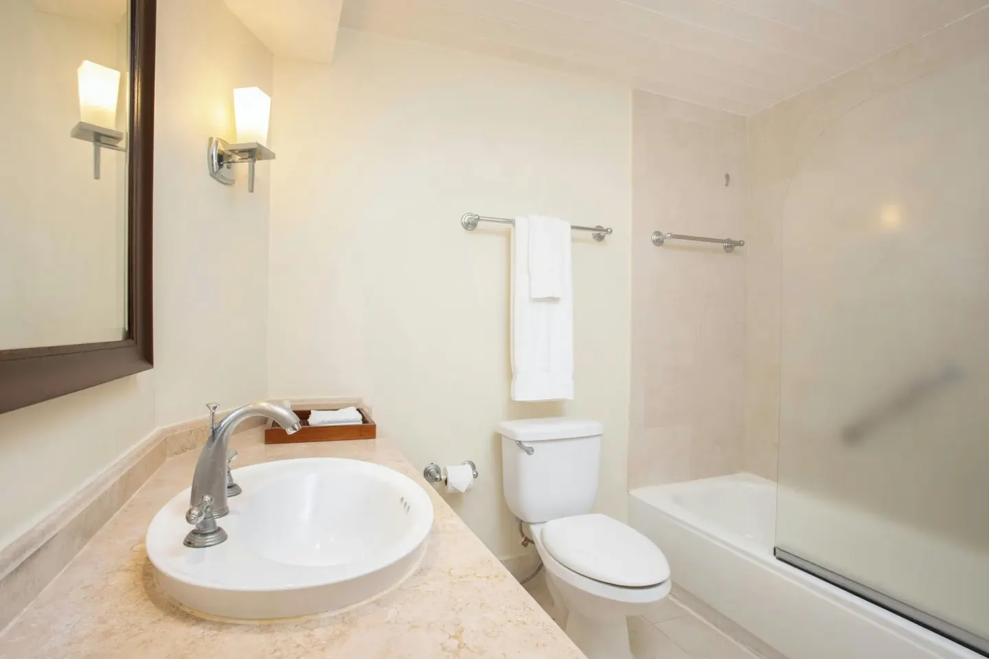 Compact bathroom with sink, toilet and frosted glass shower at Turtle Beach.