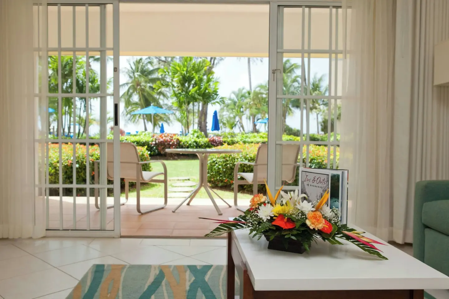 Living area opening to a garden patio with ocean glimpses at Turtle Beach.