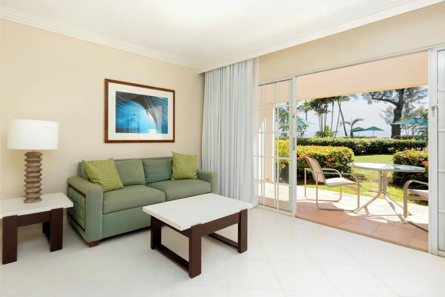 Guest room sitting area with sofa and patio garden view at Turtle Beach.