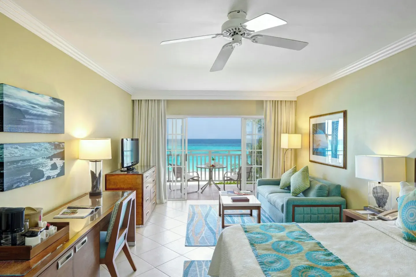 Ocean-view guest room with bed, sofa, desk, and balcony at Turtle Beach.