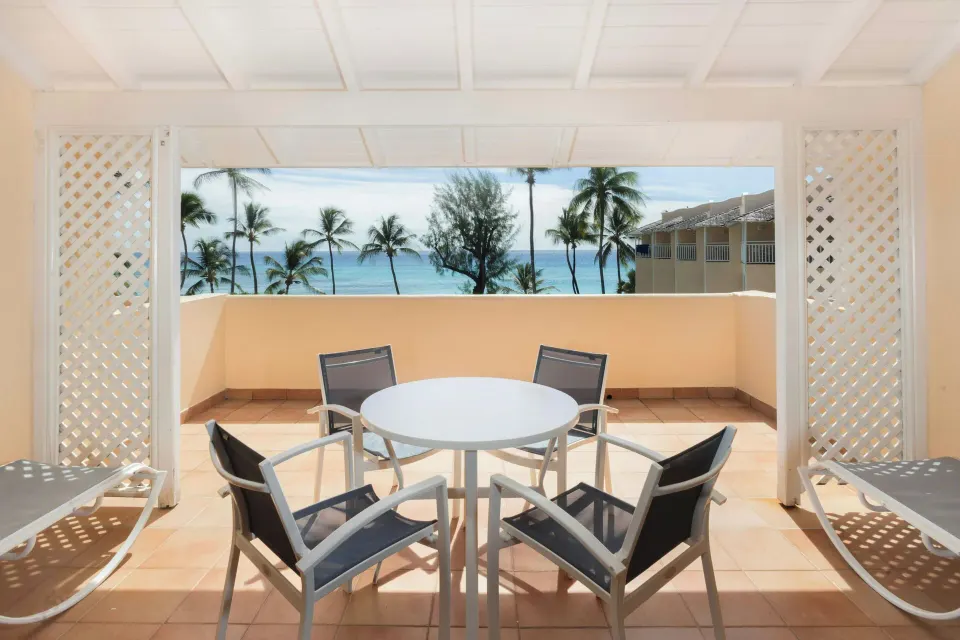 Ocean-view terrace with table, chairs and loungers at Turtle Beach.