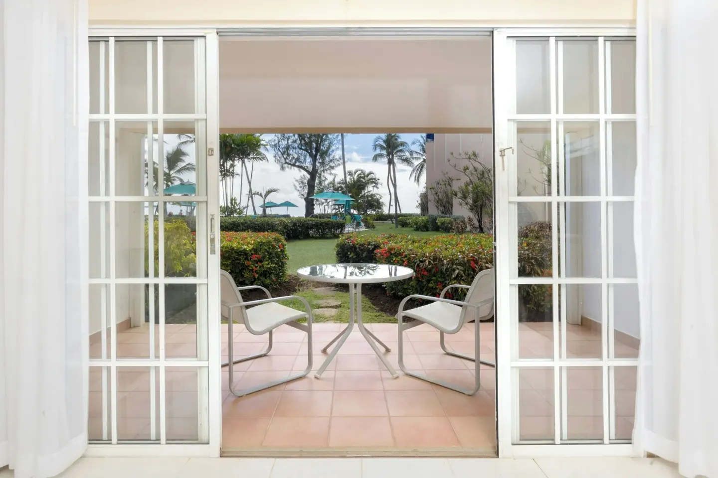 Garden-view patio with table and chairs outside a suite at Turtle Beach.