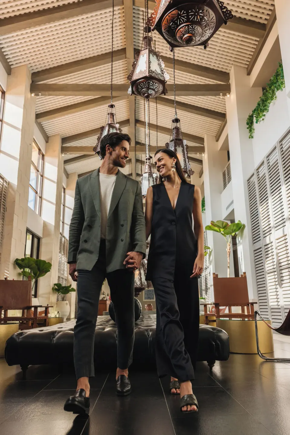 Couple walking through elegantly lit resort lobby at Unico Hotel Riviera Maya