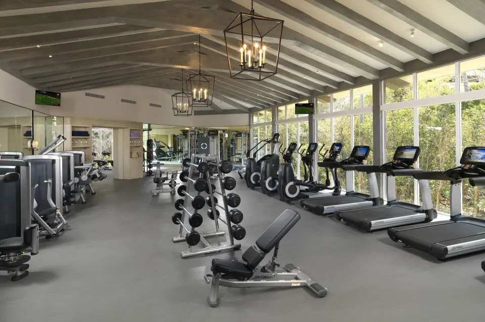 Well-equipped fitness center with treadmills and free weights at Unico Hotel Riviera Maya
