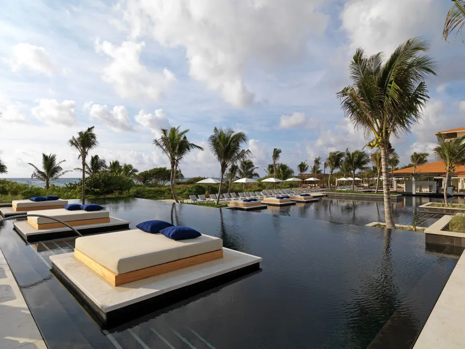Floating daybeds on a reflective pool at Unico Hotel Riviera Maya