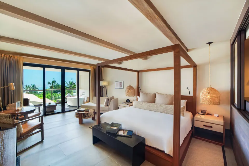Bright four-poster bed suite with sliding doors to a balcony at Unico Hotel Riviera Maya
