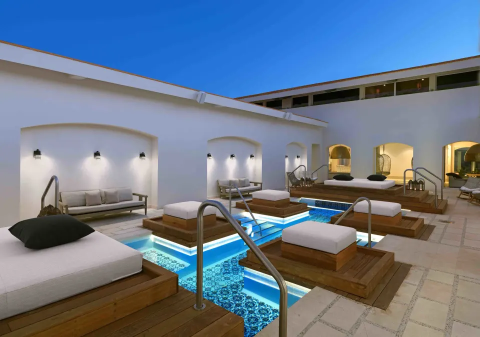 Private spa pool area with wooden platforms and daybeds at Unico Hotel Riviera Maya