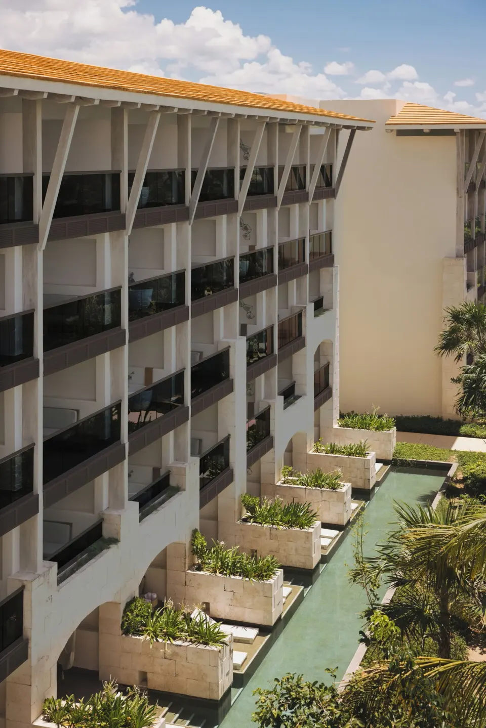 Resort building with private balcony terraces and water channel at Unico Hotel Riviera Maya