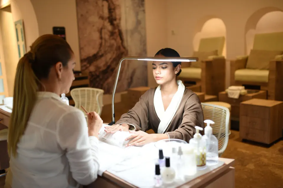 Manicurist working on a guest's hands in the spa at Unico Hotel Riviera Maya