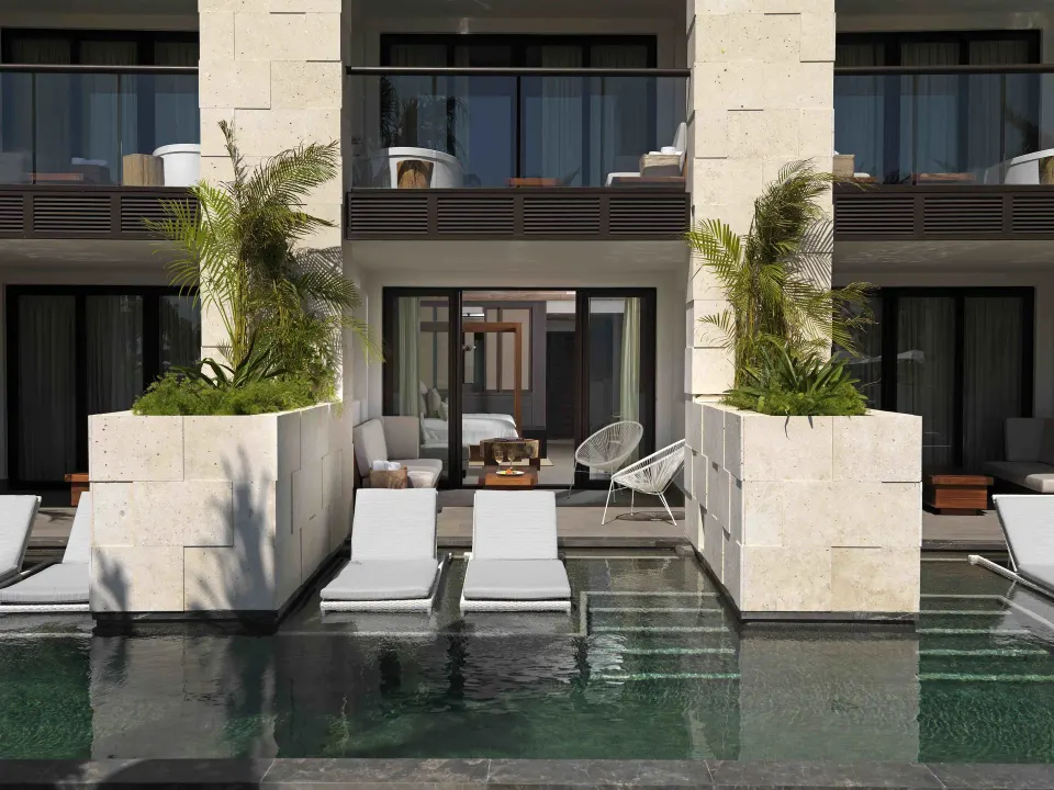 Private terrace with loungers and shallow pool in front of rooms at Unico Hotel Riviera Maya