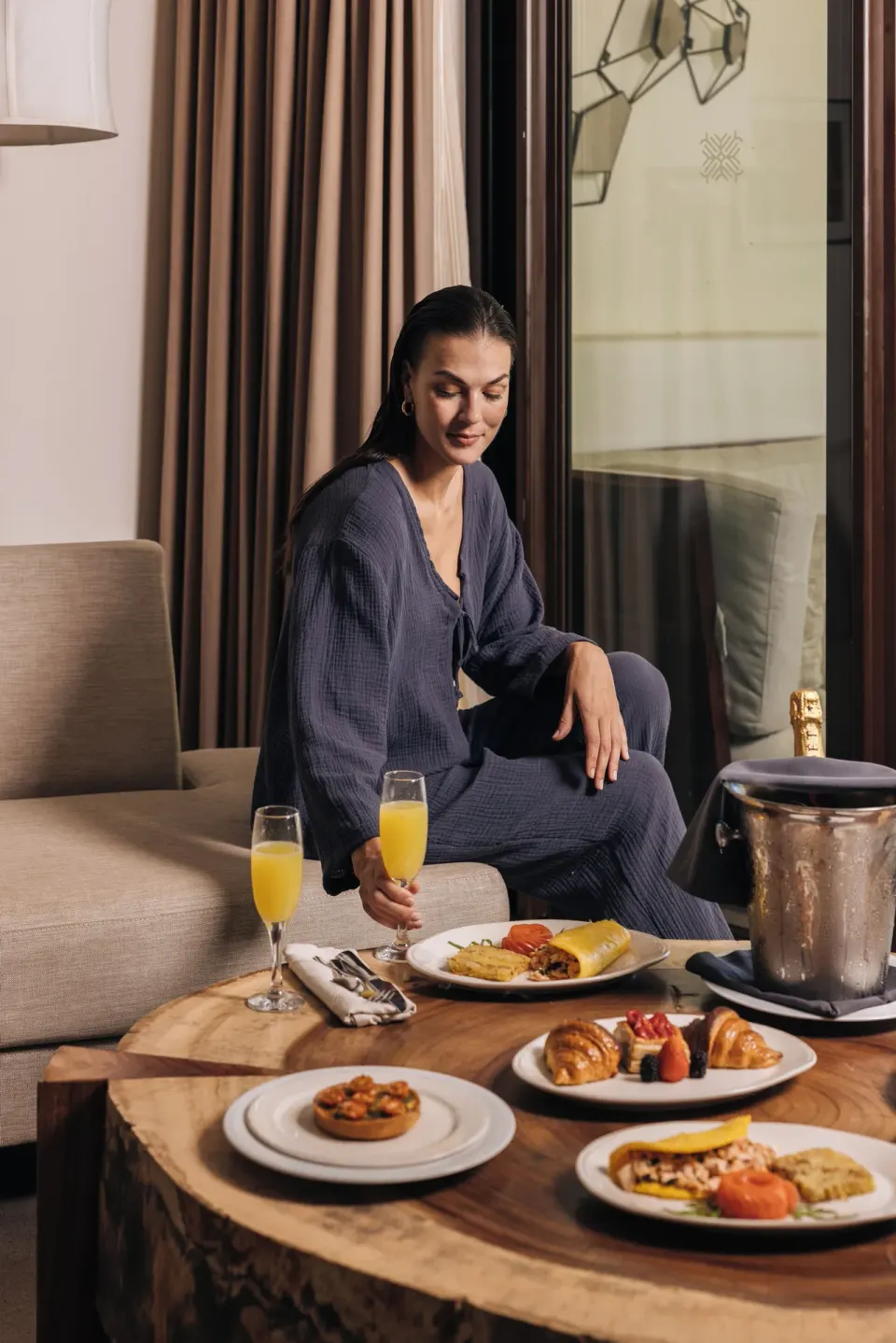 Woman enjoying in-room breakfast on a living area table at Unico Hotel Riviera Maya