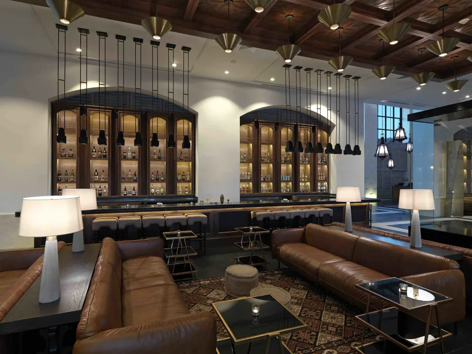 Stylish bar area with leather sofas and backlit bottle displays at Unico Hotel Riviera Maya
