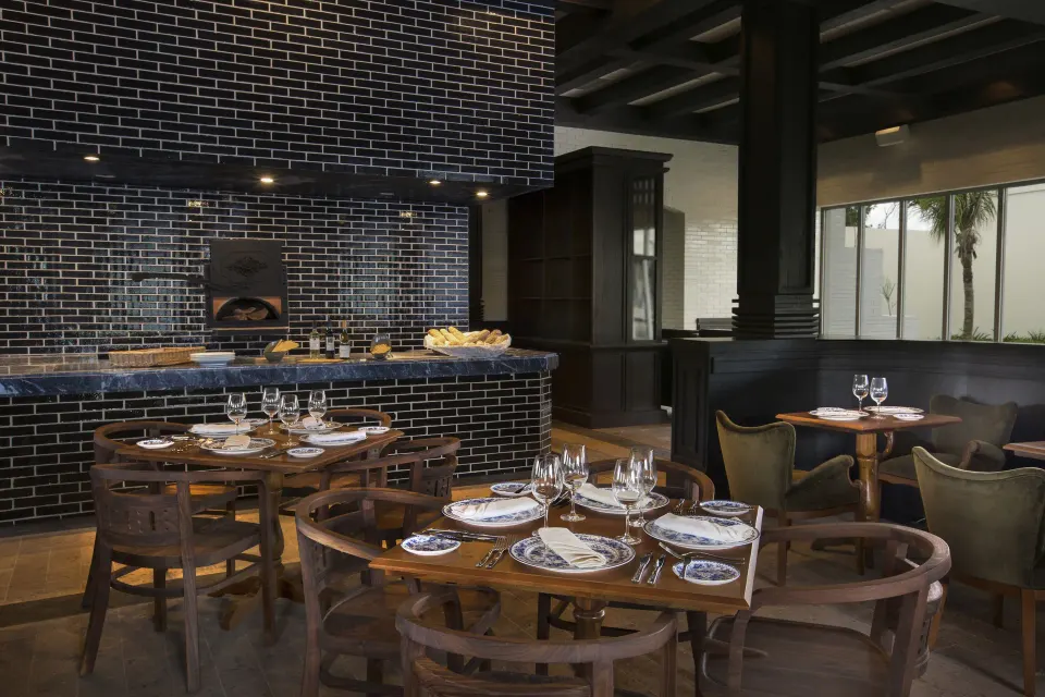 Cozy brick-oven dining room with set tables at Unico Hotel Riviera Maya