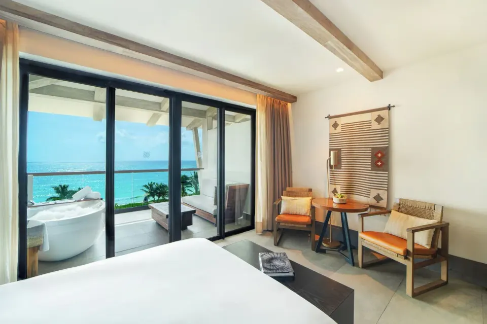 Alcoba Ocean Front Room balcony seating and sea view seen from bed at Unico Hotel Riviera Maya