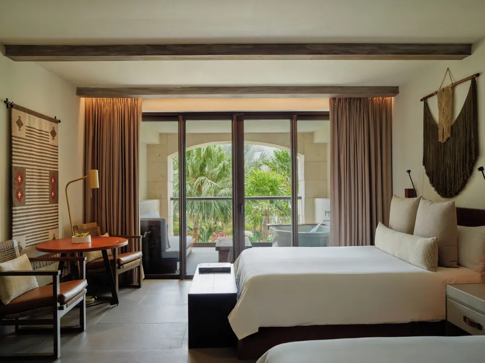 Alcoba Tropical View Room bed, desk and balcony with tropical view at Unico Hotel Riviera Maya