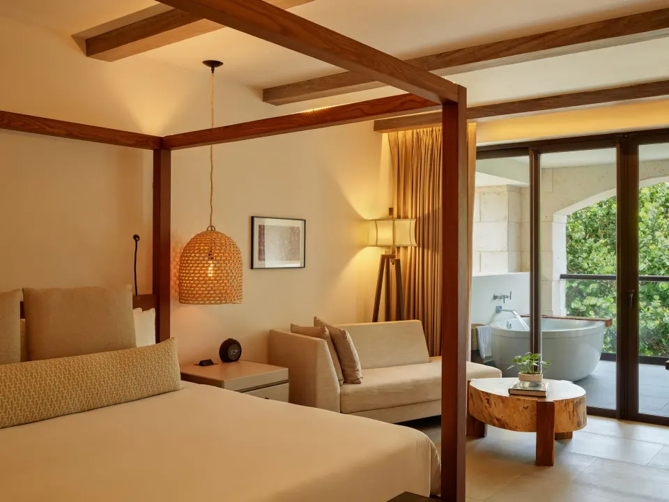Alcoba Tropical View Room king bed and seating with balcony at Unico Hotel Riviera Maya