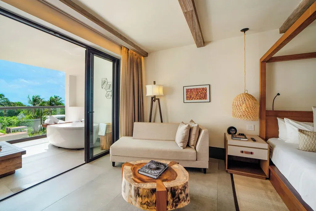 Alcoba Tropical View Room seating area and balcony with tub at Unico Hotel Riviera Maya