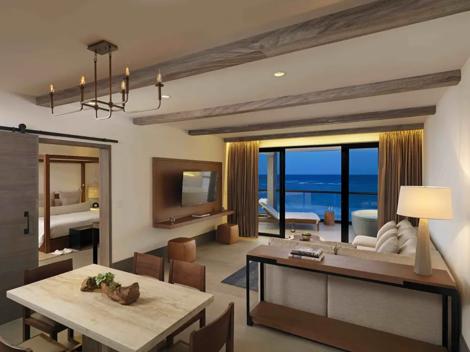 Estancia Suite one-bedroom living area with ocean view and sliding doors at Unico Hotel Riviera Maya