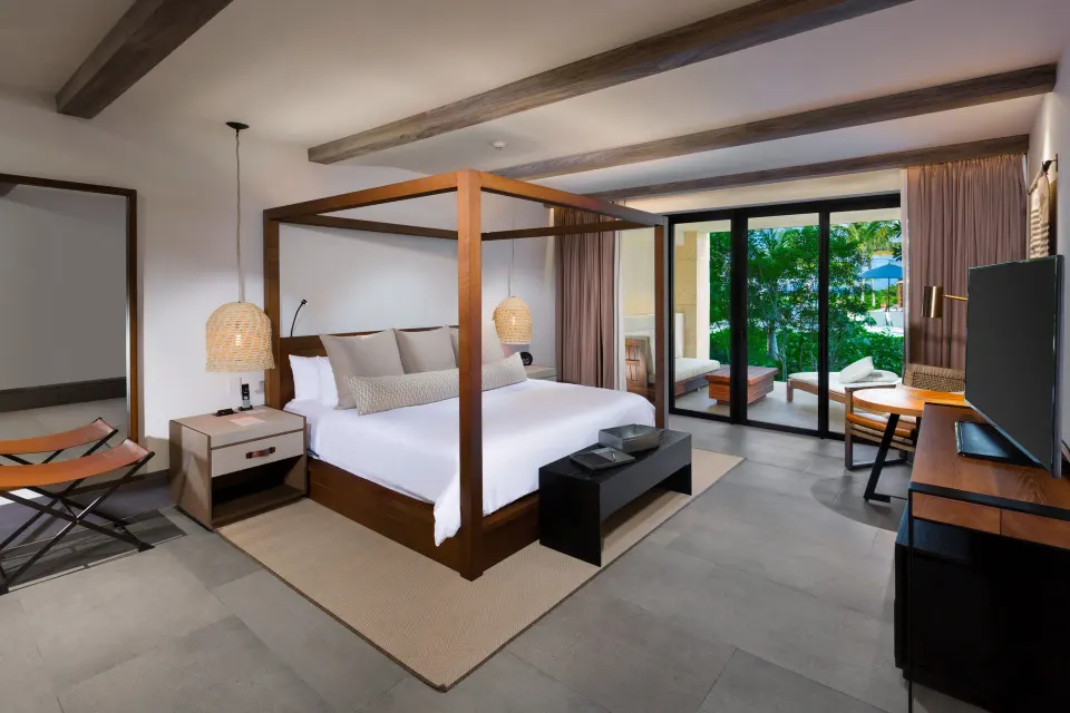 Four‑poster king bed and terrace view in an Estancia Suite at Unico Hotel Riviera Maya