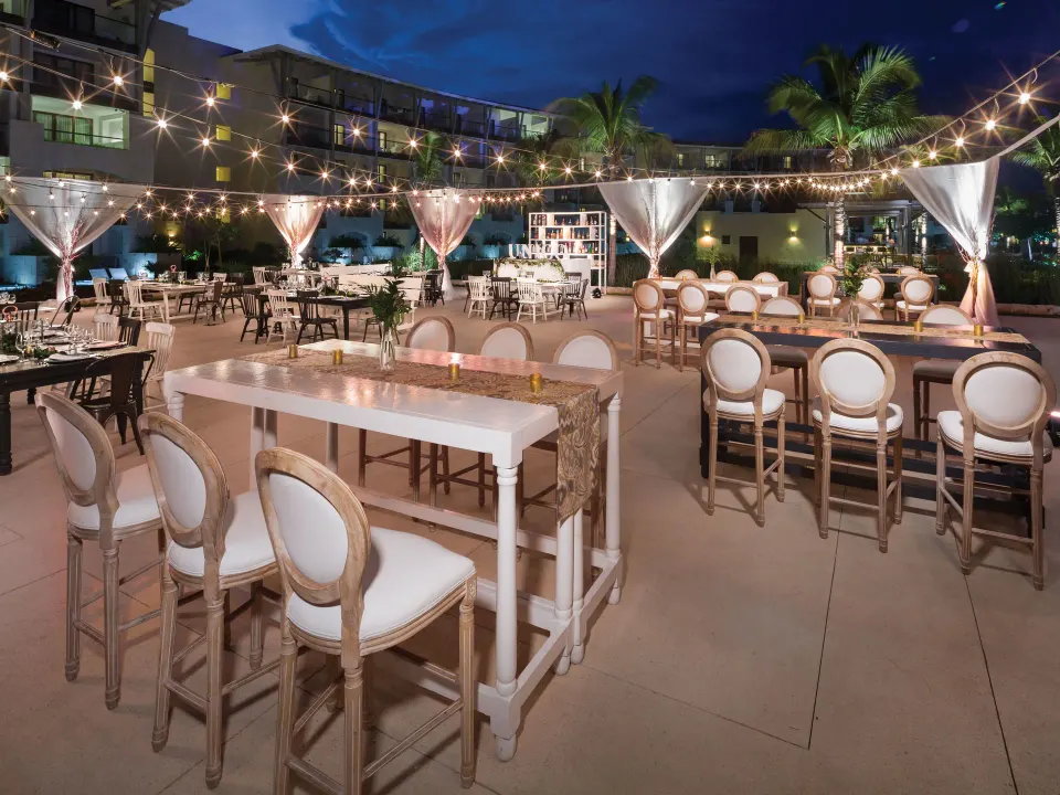 Evening outdoor dining area with string lights and tables at Unico Hotel Riviera Maya