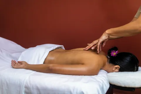 A guest receives a back massage in a spa room at Valentin Imperial Riviera Maya.