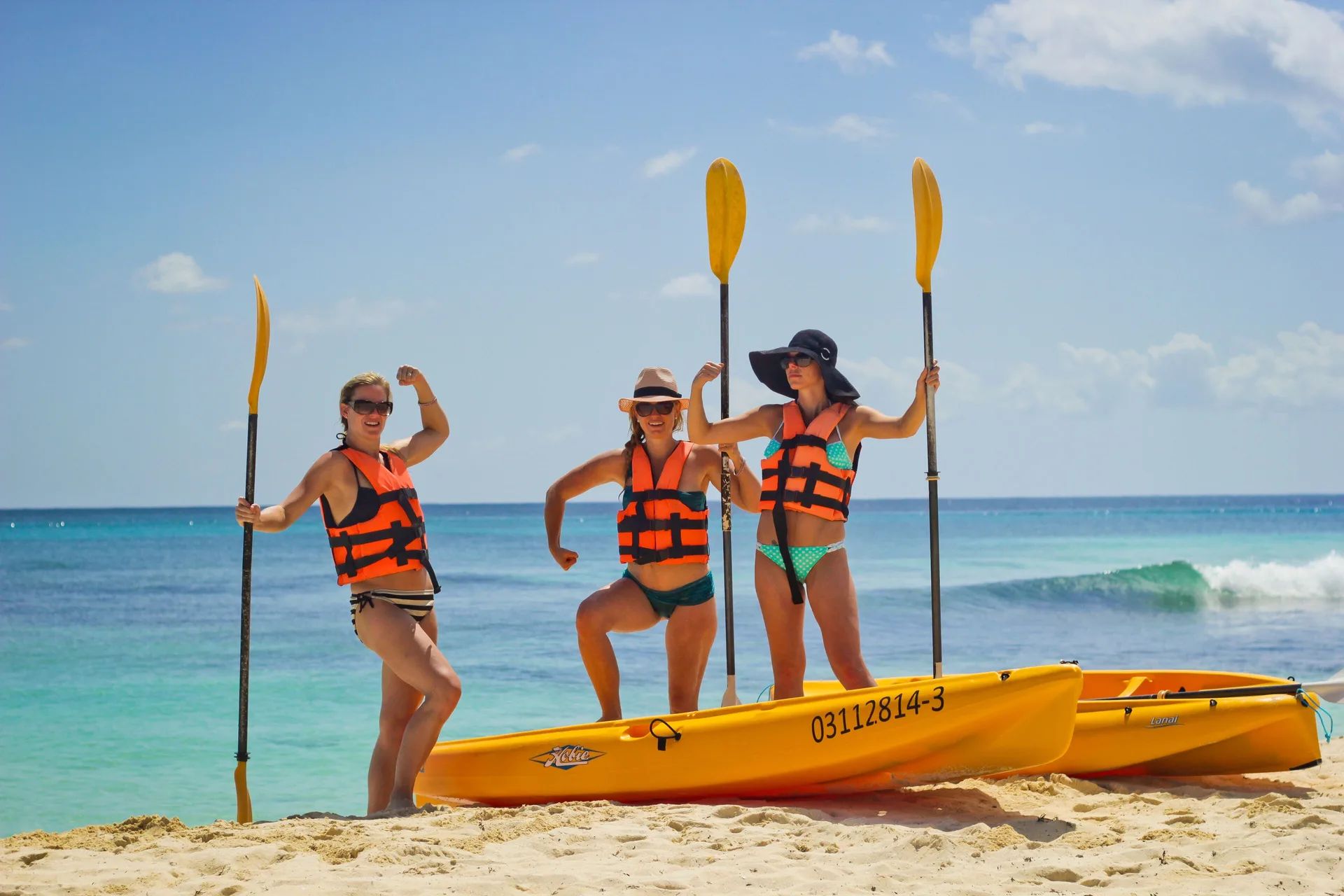 Guests pose with kayaks on the beach at Valentin Imperial Riviera Maya.