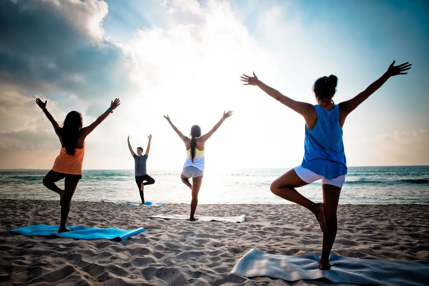 Beach yoga class on mats facing the ocean at Valentin Imperial Riviera Maya.
