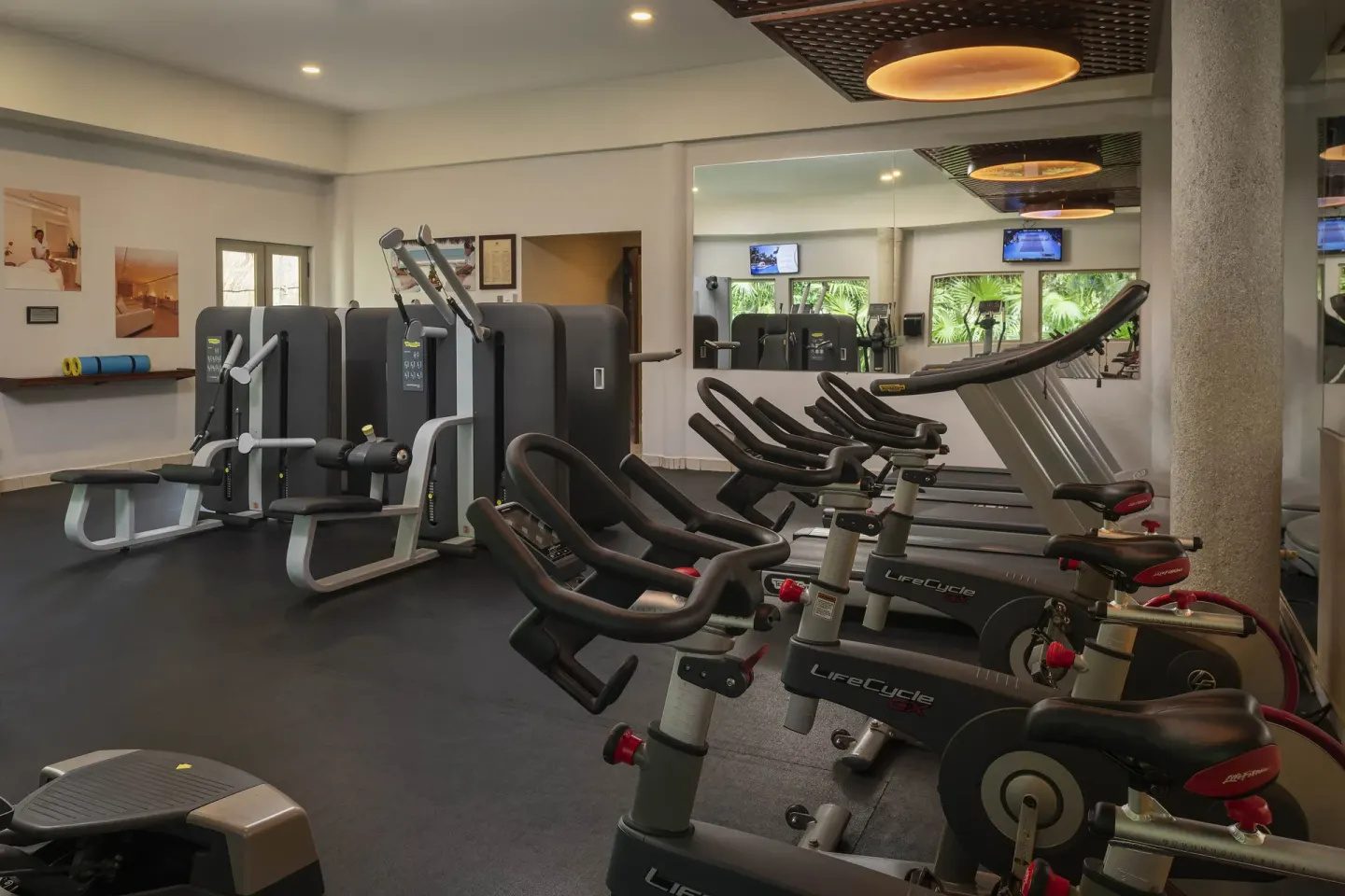 Fitness center with exercise bikes, machines and mirrored wall at Valentin Imperial Riviera Maya.