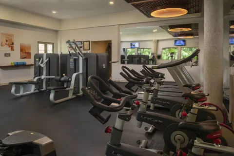 Fitness center with exercise bikes, machines and mirrored wall at Valentin Imperial Riviera Maya.