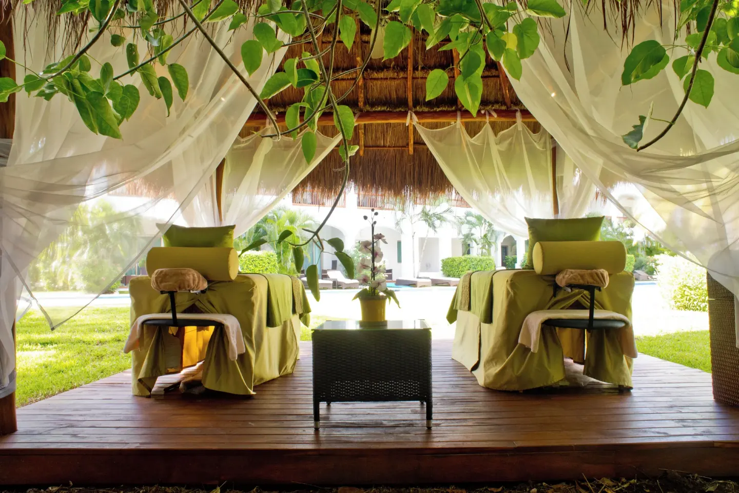 Two outdoor spa loungers sit under sheer curtains at Valentin Imperial Riviera Maya.