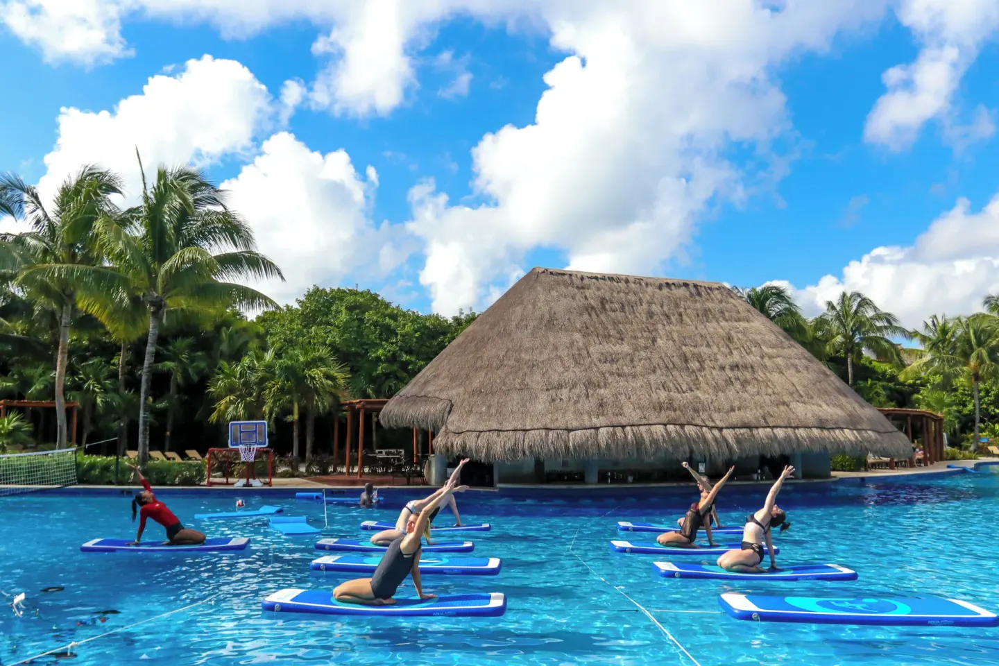 Guests doing paddleboard yoga in the pool at Valentin Imperial Riviera Maya.