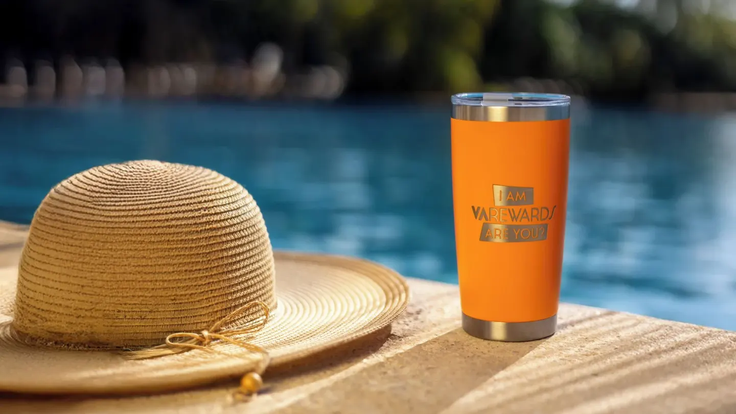 Sun hat and orange travel tumbler beside the pool at Valentin Imperial Riviera Maya.