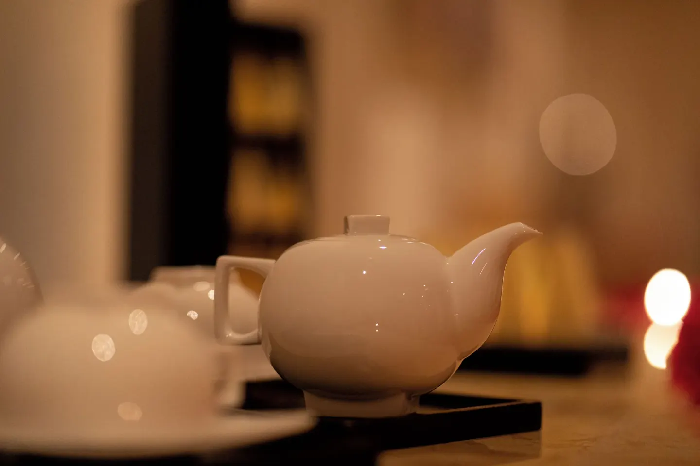 A white teapot sits on a tray in a softly lit spa setting at Valentin Imperial Riviera Maya.
