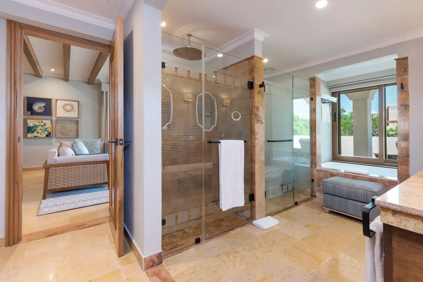 Suite bathroom with glass shower, tub and living room doorway at Valentin Imperial Riviera Maya.