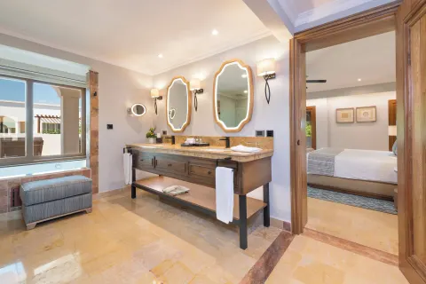 Bathroom vanity and bedroom doorway in a suite at Valentin Imperial Riviera Maya.