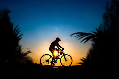 A cyclist is silhouetted at sunset near Valentin Imperial Riviera Maya.