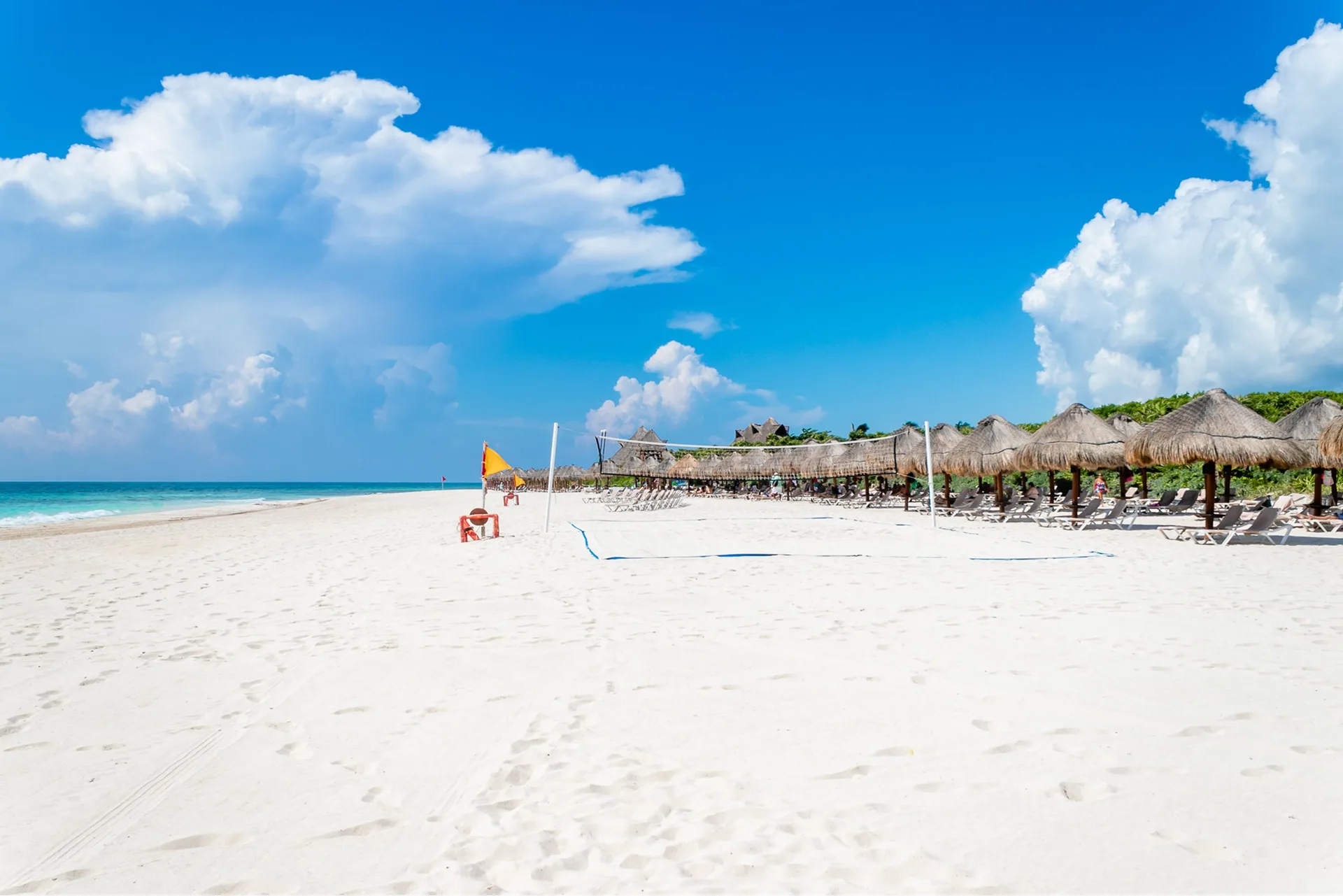Wide white-sand beach with palapas and loungers at Valentin Imperial Riviera Maya.
