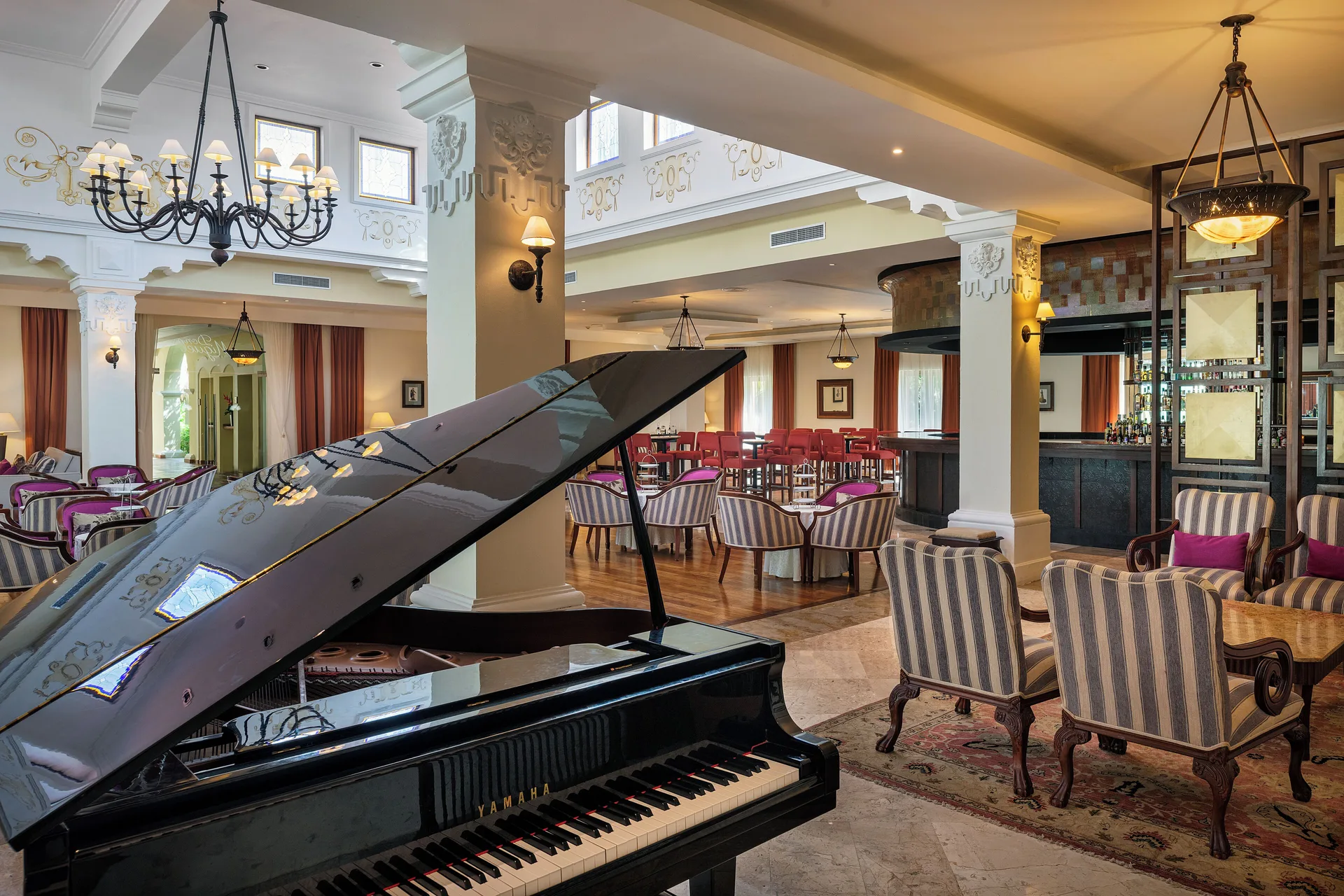 Grand piano and lounge seating in an elegant bar at Valentin Imperial Riviera Maya.