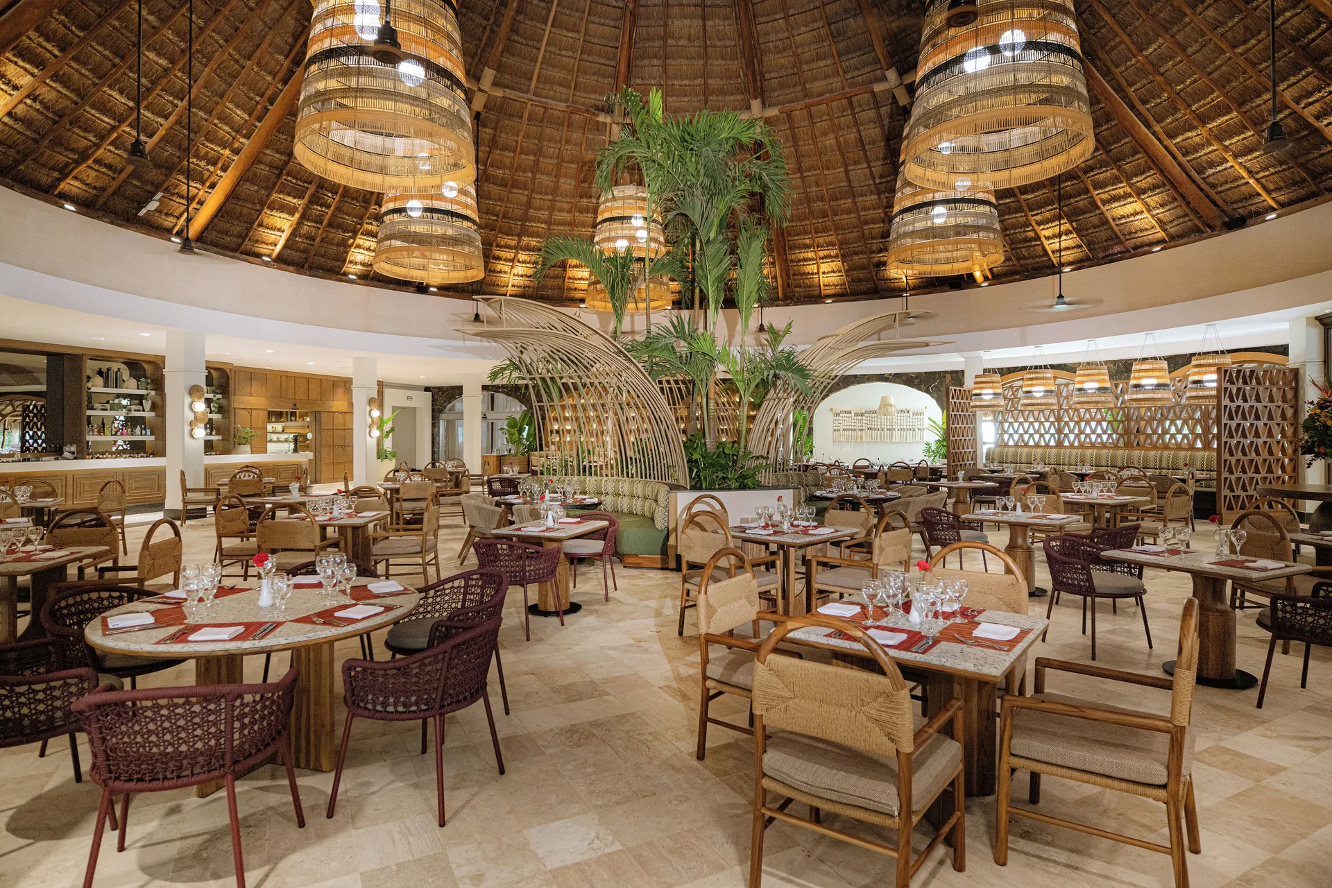 Thatched-roof dining room with set tables at Valentin Imperial Riviera Maya.
