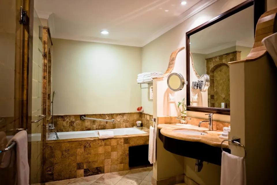 Deluxe Junior Suite bathroom with stone tub and vanity at Valentin Imperial Riviera Maya.