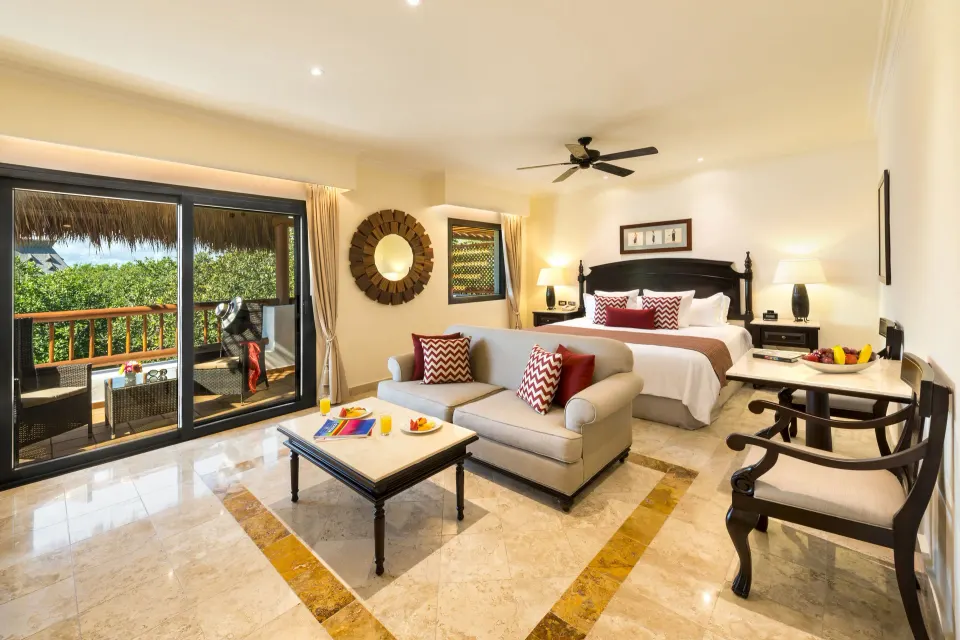 Deluxe Junior Suite garden-view room with king bed and balcony at Valentin Imperial Riviera Maya.